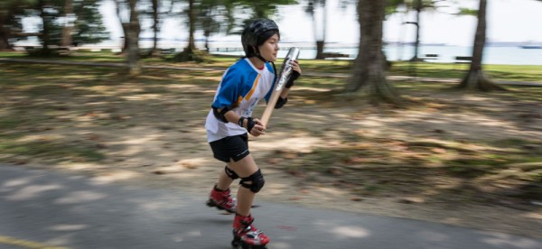 Melissa Leow, on rollerblades, carries the Queen's Baton in Singapore, on Thursday 24 October 2013. Singapore is the sixth country to be visited during the Asian leg of the baton's journey through 70 Commonwealth nations and territories.